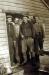 Four miners standing outside of their boarding house