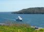 Yacht heads north to the Canso Canal. Mainland Nova Scotia is seen on opposite shore.