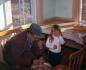 'Ti Boise' making pegs in his kitchen with his grand daughter Kim standing nearby.