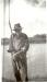 An elderly Cree man holding a fishing pole.