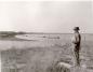 Man standing on the bank where the Saskatchewan River meets the Pasquia River (The Pas Docks).