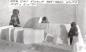 Inuit men building an iglu