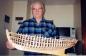 Henry Vokey displaying a model boat which he is constructing.