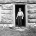 Stan Gamble in front of log cabin