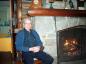 Past President Maurice Butler by fire in Log Cabin
