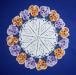 Crocheted doily with orange and violet pansies