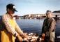 Harold Harnum (left) and Tom Brinson (right) are gutting their catch of cod on the waterfront.